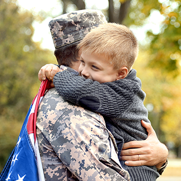 kid hugging dad in uniform
