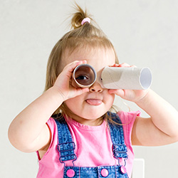 Toddler looking through pretend binoculars