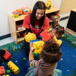 Maestra y niños jugando con grandes legos