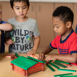 Two boys building a house with blocks